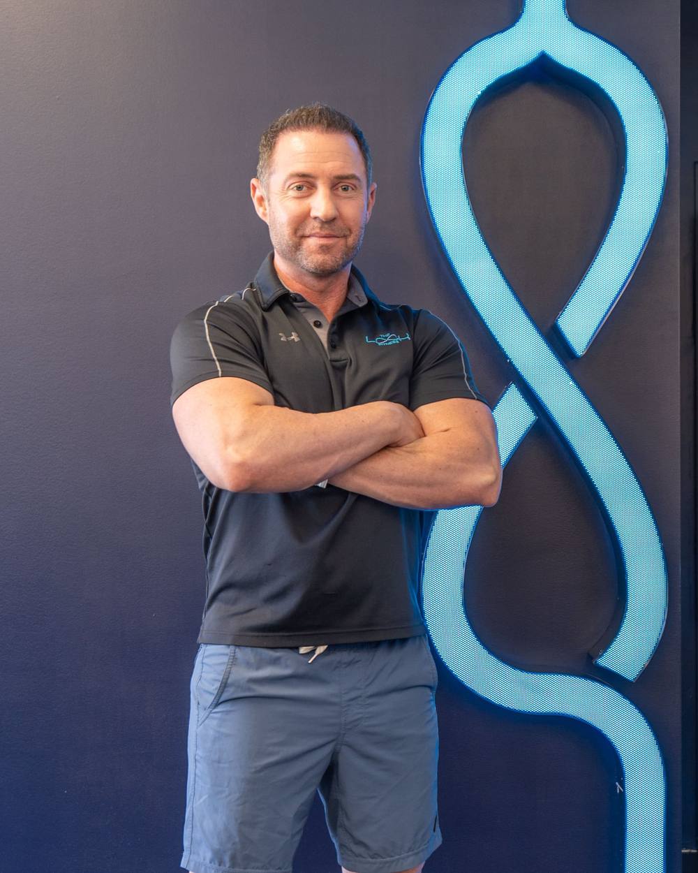 Bryan Greene, founder of The LOOK Fitness, in front of the studio’s illuminated logo