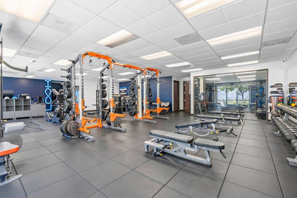 The main training floor at The LOOK Fitness, with orange racks, benches and machines
